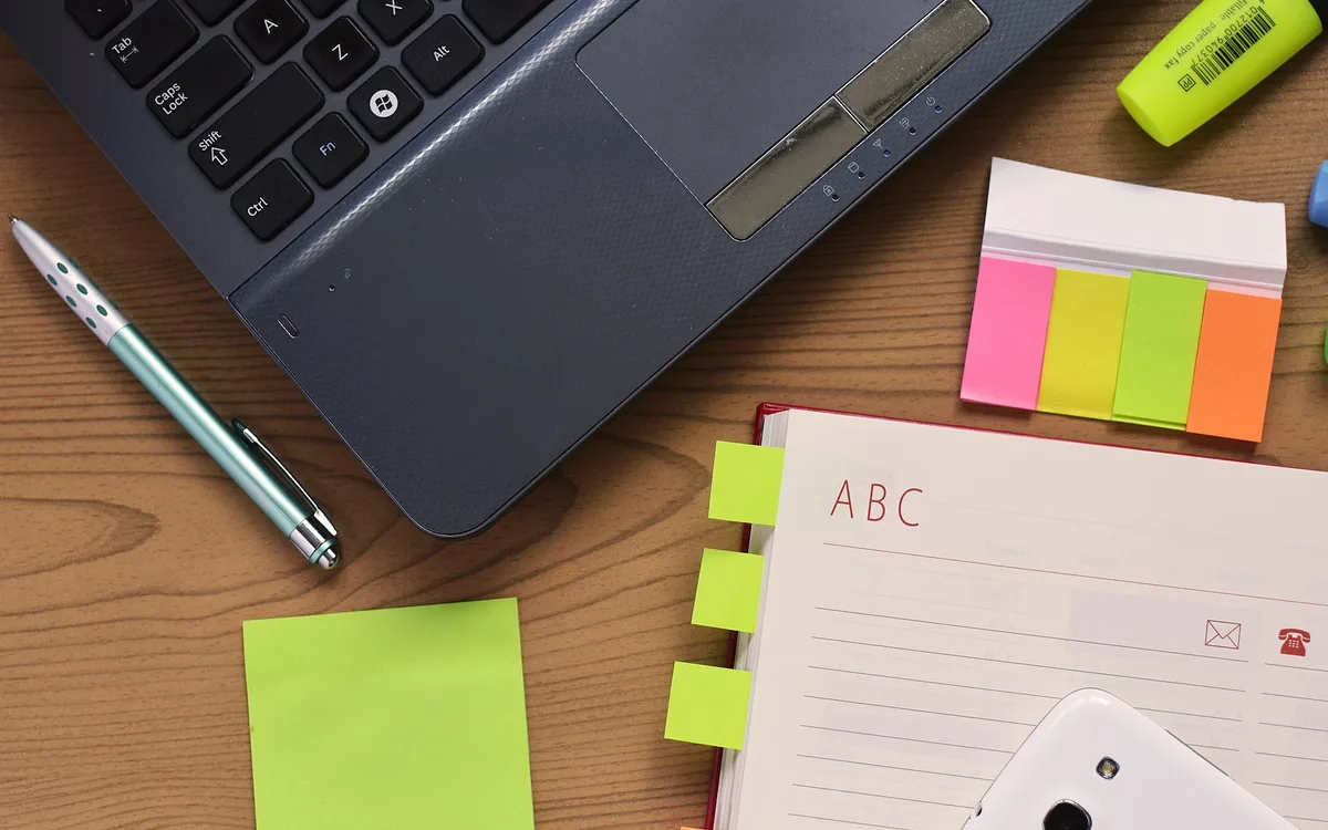 A notebook and laptop on a desk